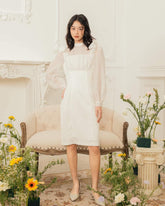Organza knee-length dress with sheer puff sleeves and bow accents for feminine elegance