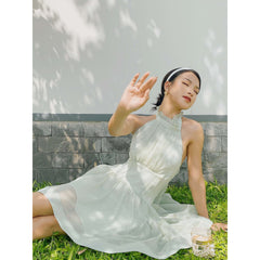 Sleeveless organza halter mini dress with tie-back detail and softly flared skirt