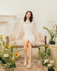 Organza knee-length dress with sheer puff sleeves and bow accents for feminine elegance