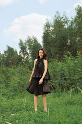 High-neck pleated silk dress with peplum waist and sleeveless halter silhouette