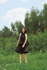 High-neck pleated silk dress with peplum waist and sleeveless halter silhouette