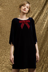 Velvet shift dress with oversized bow detail and relaxed mid-thigh silhouette for evening elegance