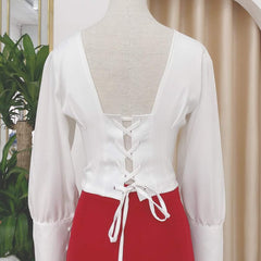 Silk blouse with puff sleeves, V-neckline, and lace-up back detail for elegant styling