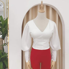 Silk blouse with puff sleeves, V-neckline, and lace-up back detail for elegant styling