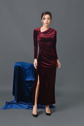 Velvet long-sleeve evening gown with draped neckline and high slit in floor-length silhouette