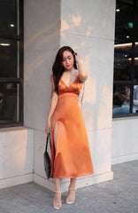 Sleeveless silk midi dress with deep V-neckline and front slit for elegant summer styling