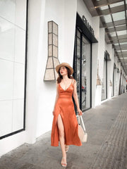 Sleeveless silk midi dress with deep V-neckline and front slit for elegant summer styling