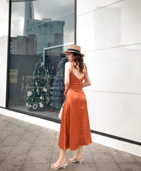 Sleeveless silk midi dress with deep V-neckline and front slit for elegant summer styling