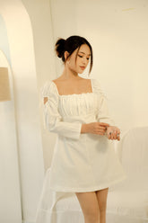 Silk mini dress with ruched bodice and puff sleeves featuring delicate bow-tie accents