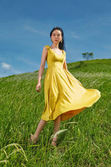 Sleeveless A-line midi dress crafted in smooth silk with soft pleats and romantic shoulder ties