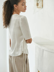 Elegant wrap-style linen blouse with side tie and soft tailored silhouette
