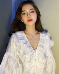Chemisier à volants en soie avec fronces sur le devant et manches longues fluides pour un style élégant
