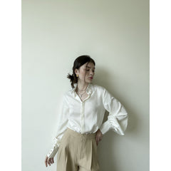 Silk blouse with tailored collar, voluminous sleeves, and pearl-detailed buttoned cuffs