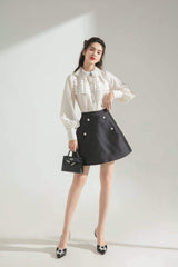 Silk A-line skirt with pearl button accents and structured silhouette for elevated daywear