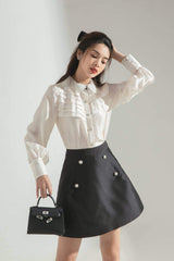 Silk A-line skirt with pearl button accents and structured silhouette for elevated daywear