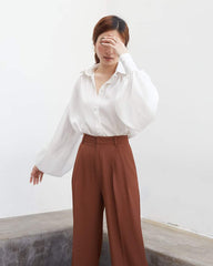 Wide-leg silk pants with high-rise waist and tailored pleats for effortless sophistication