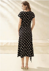Silk polka dot dress with cowl neckline and asymmetrical hem for a playful feminine look