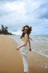 Bias-cut silk dress with ruched detail and thigh-high slit for elegant beach styling