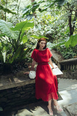 Pleated silk midi dress with soft sheer overlay and gathered waistline for elegant movement