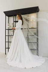 Long sleeve A-line silk dress with boat neckline and open back detailing for formal occasions