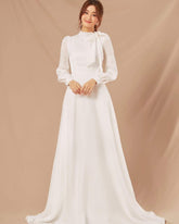 Silk long-sleeve high-neck gown with bow tie detail and flowing A-line floor-length skirt