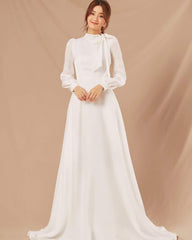 Silk long-sleeve high-neck gown with bow tie detail and flowing A-line floor-length skirt