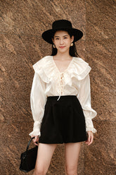 Sheer organza blouse with ruffled collar and voluminous long sleeves for statement style