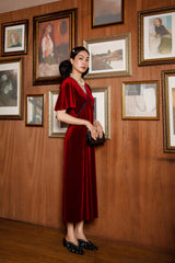 Elegant velvet midi dress with flutter sleeves and soft draped silhouette for timeless evening style