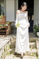 Off-shoulder long sleeve gown in flowing silk with elegant A-line silhouette