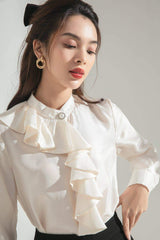 Silk blouse with cascading front ruffle and pearl collar button for timeless feminine elegance