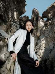 Tailored textured fabric long coat with peak lapels and buttoned cuffs for elegant layering