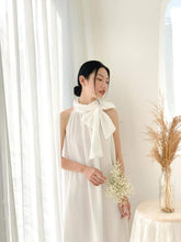 Silk halter dress with oversized bow neckline and flowy A-line silhouette for modern elegance