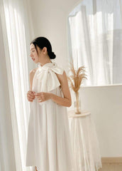 Silk halter dress with oversized bow neckline and flowy A-line silhouette for modern elegance