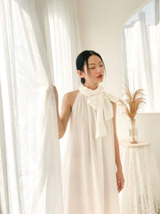 Silk halter dress with oversized bow neckline and flowy A-line silhouette for modern elegance