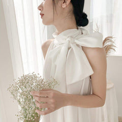Silk halter dress with oversized bow neckline and flowy A-line silhouette for modern elegance