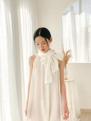 Silk halter dress with oversized bow neckline and flowy A-line silhouette for modern elegance