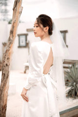 Long sleeve silk dress with open back and full-length A-line skirt for formal occasions