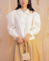 Silk blouse with puff sleeves and pearl buttons featuring delicate ruffled collar detailing
