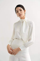 Silk blouse with high neckline, sculpted necktie detail, and tailored long sleeves