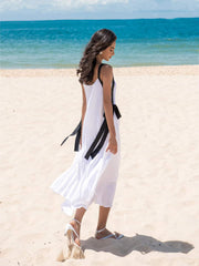 Flowy pleated silk dress with wide shoulder straps and bow-tie accents