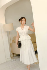 Cotton poplin peplum top with gathered neckline, cap sleeves, and adjustable tie front