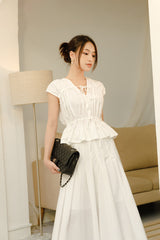 Cotton poplin peplum top with gathered neckline, cap sleeves, and adjustable tie front