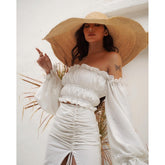 Silk blouse with off-shoulder neckline and ruched puff sleeves paired with ruched silk skirt