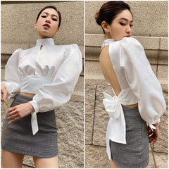 Silk blouse with puff sleeves, high neckline, open back, and waist tie detailing