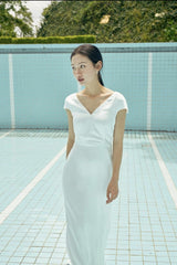 Robe longue élégante en soie avec col en V sur le devant et détail nœud dans le dos ouvert