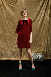 Velvet shift dress with oversized bow detail and relaxed sleeves for festive party looks