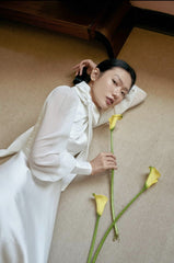 Elegant floor-length silk dress with sheer sleeves and high neck bow detail