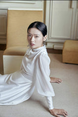 Elegant floor-length silk dress with sheer sleeves and high neck bow detail