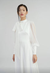 Elegant floor-length silk dress with sheer sleeves and high neck bow detail