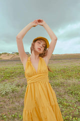 Tiered halter midi dress crafted from flowing silk with open back and adjustable waist tie